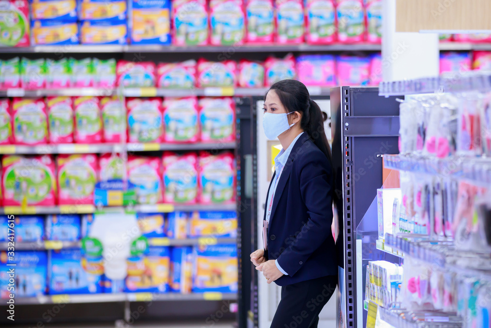 Owner business in medical protective mask standing and looking to her store Owner business in medical protective mask standing and looking to her store