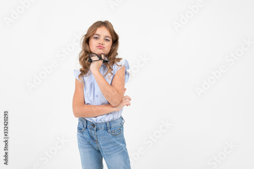 stylish teenager girl took off glasses for vision and holds in her hand on a white background with copy space