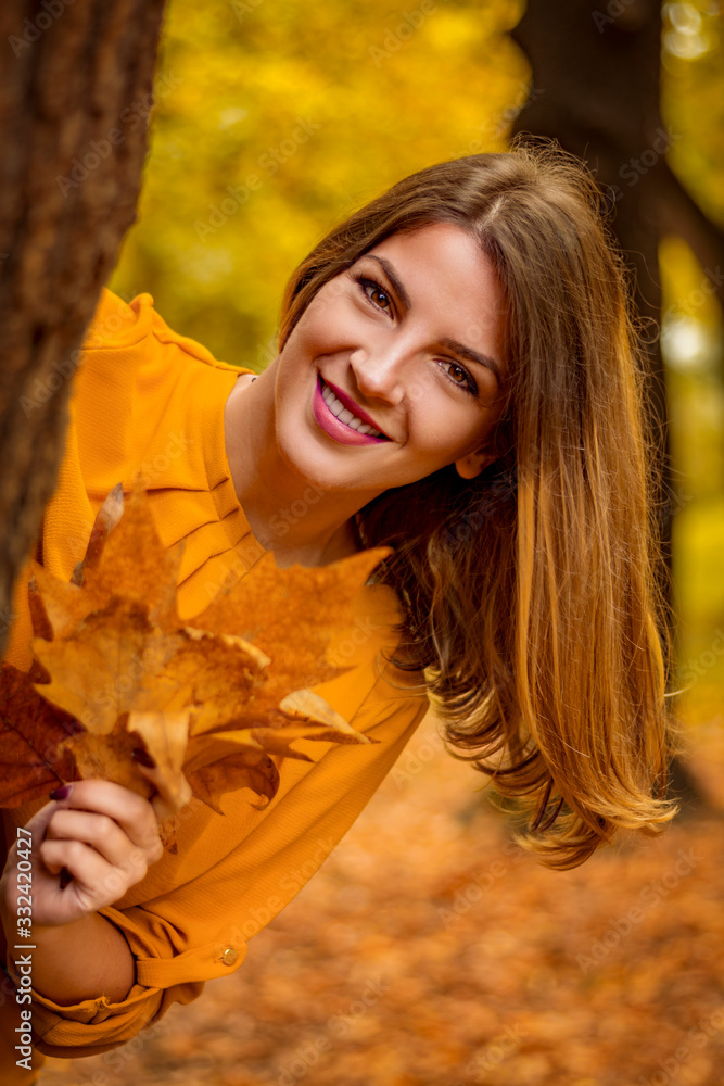 Cute smiley woman holding autumn leafs in the nature.. Cute smiley woman holding autumn leafs in the nature..