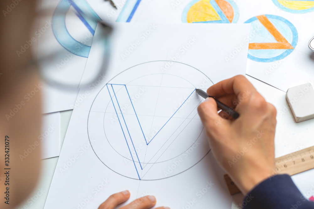 Graphic designer draws a sketch of a brand logo. Graphic designer draws a sketch of a brand logo.