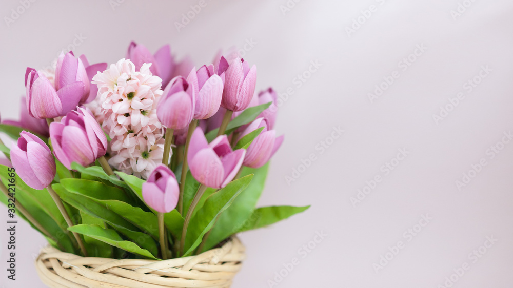 Obraz premium Beautiful artificial tulips in a wicker basket.