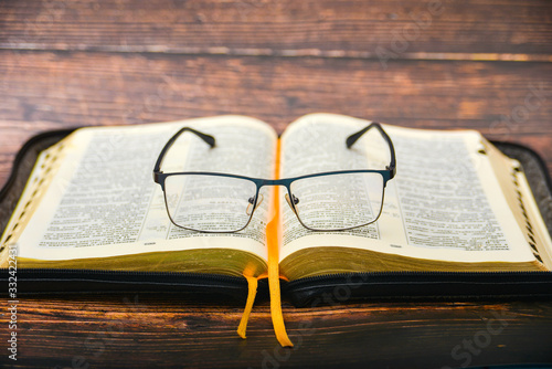 Schilderij op canvas The Bible and glasses, glasses for sight lie on the opened Bible of a gift issue with gilded pages