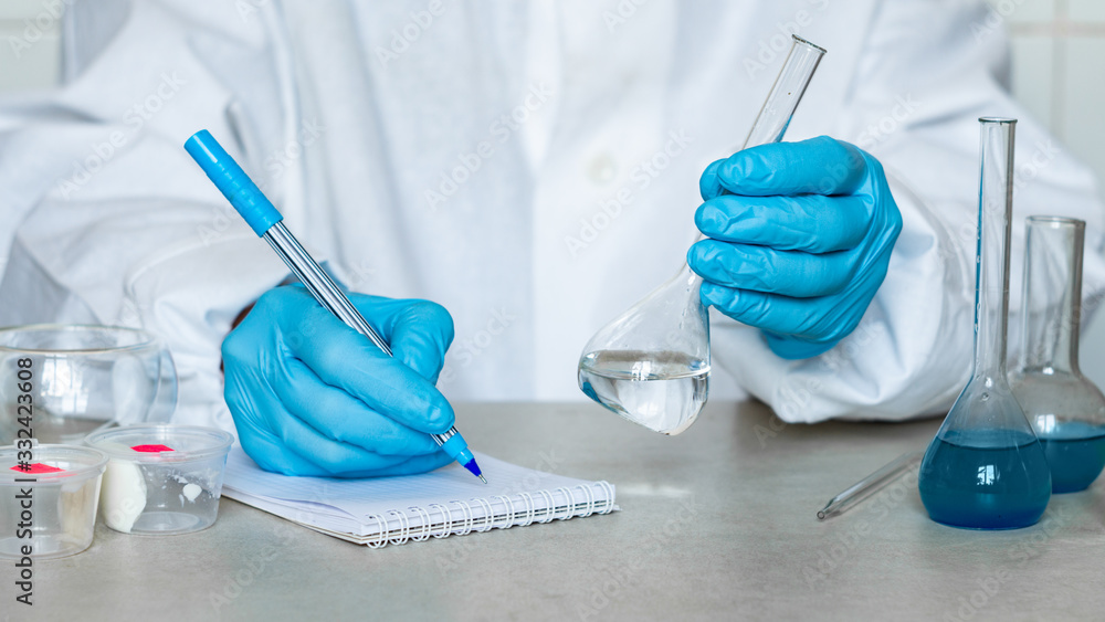 Fototapeta premium Chemist or pharmacologist examines samples of substances in a laboratory