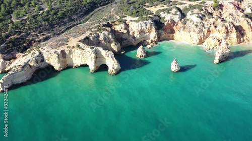 Arch rock formations in Marinha Beach south of Portugal, Aerial dolly lowering shot photo