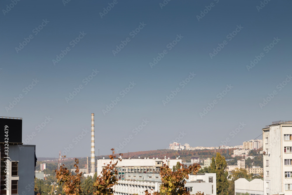 Top view of chimneys of plant and city buildings.