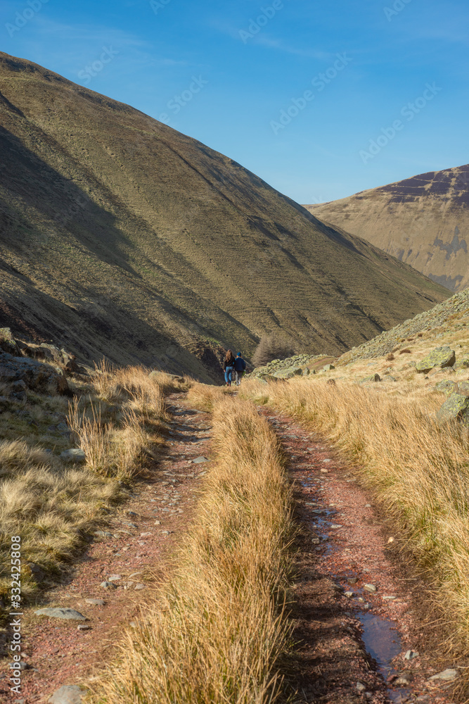 Girls Walk Along a Remote Hiking Trail in Dramatic Hills in Scotland