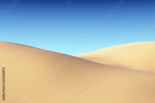 Smooth sand dunes with waves under blue sky