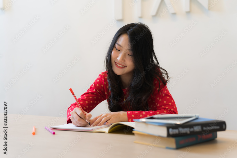 Close-up of female students taking notes on the notebook. Close-up of female students taking notes on the notebook.