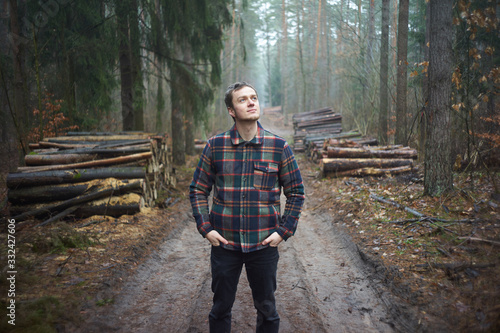 Caucasian man has a walk in foggy forest and enjoys environment photo