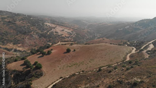 Aerial drone view of desert orange mountains with rare green bushes