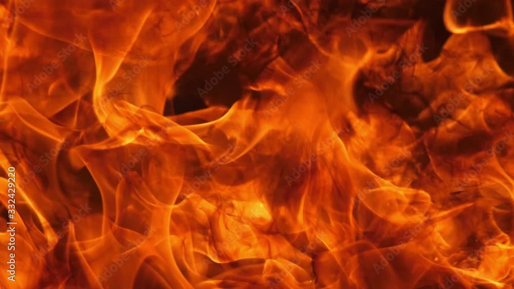 Slow motion speed close up scene of moving burning pattern as background. hot as inferno flame concept, abstract beautiful fire texture with flakes of spark, black smoke from petroleum oil ignition