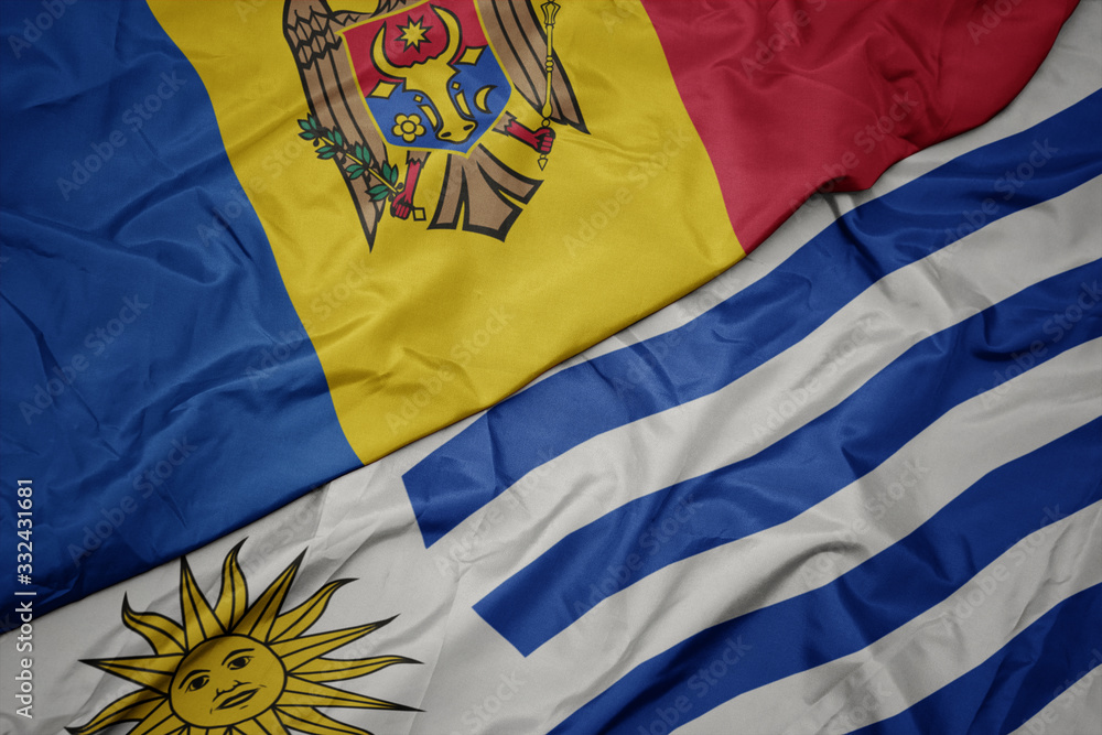 waving colorful flag of uruguay and national flag of moldova.