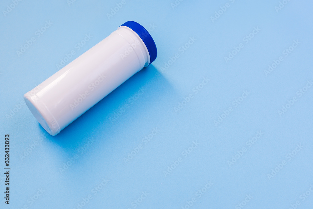 White plastic bottle with a blue cap without a label with copy space. Bank for storage of hygiene products, wet wipes, cotton pads. Cosmetic products on a blue background. White plastic bottle with a blue cap without a label with copy space. Bank for storage of hygiene products, wet wipes, cotton pads. Cosmetic products on a blue background.