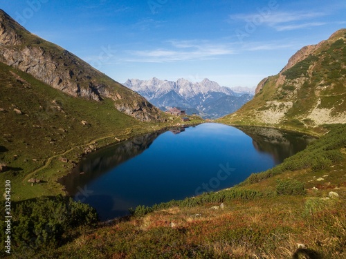 flowing of the wild lake in Austrian Alps  epic landscape scenery  snowy mountains in back