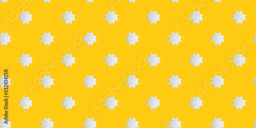 Pattern made of medical surgical masks on yellow background.