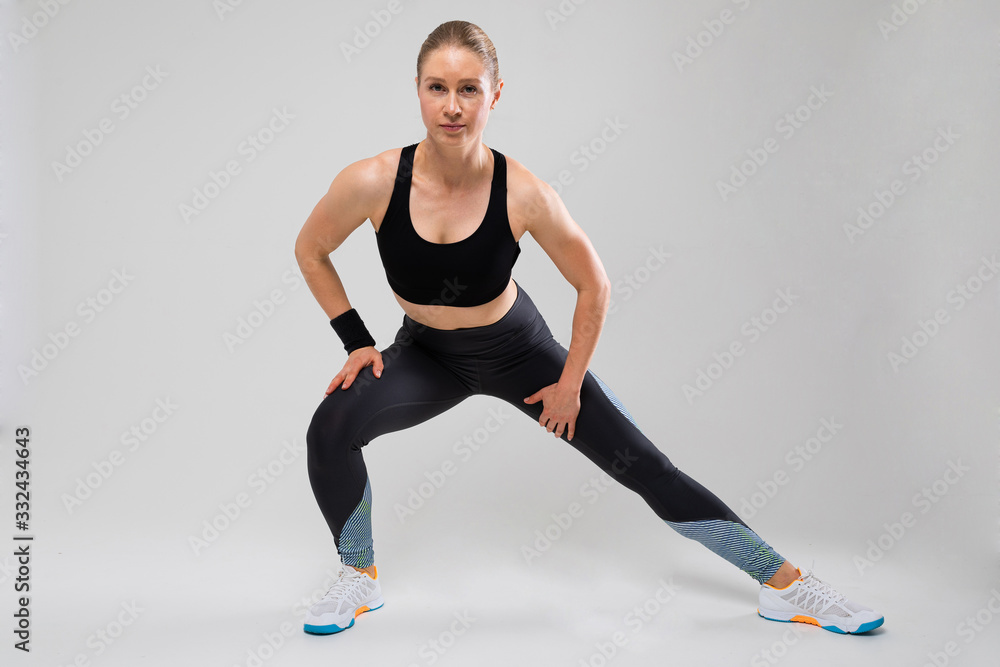 fit girl shows exercises for the body on a gray background fit girl shows exercises for the body on a gray background