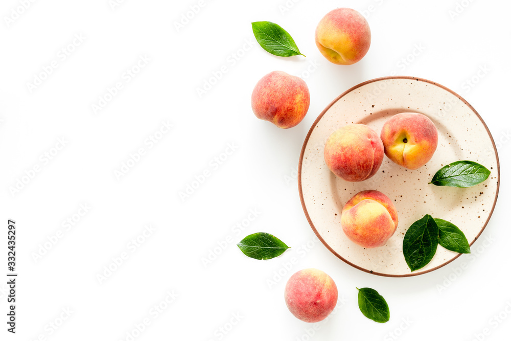 Summer fruits. Ripe red peaches on plate on white table top-down copy space Summer fruits. Ripe red peaches on plate on white table top-down copy space