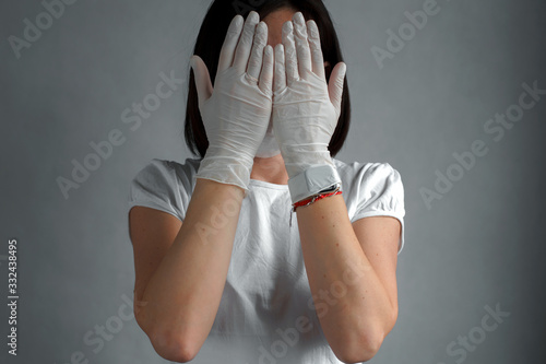 Women doctor wearing protection face mask against coronavirus. White clothes and gloves.