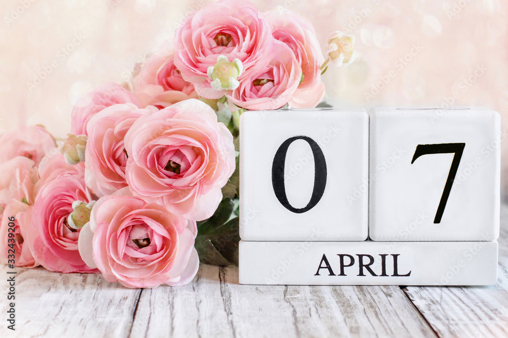 Fototapeta premium White wood calendar blocks with the date April 7th. Selective focus with blurred background.