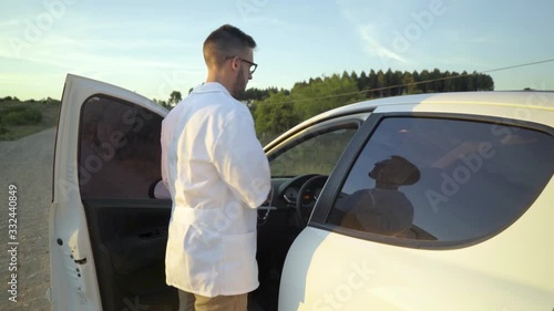 Rural man doctor gets out of the car on dirt road photo