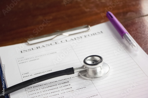 The stethoscope put on blurred Insurance claim form,blurry light around