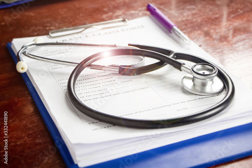 The stethoscope put on blurred Insurance claim form,Lens flare effect,blurry light around