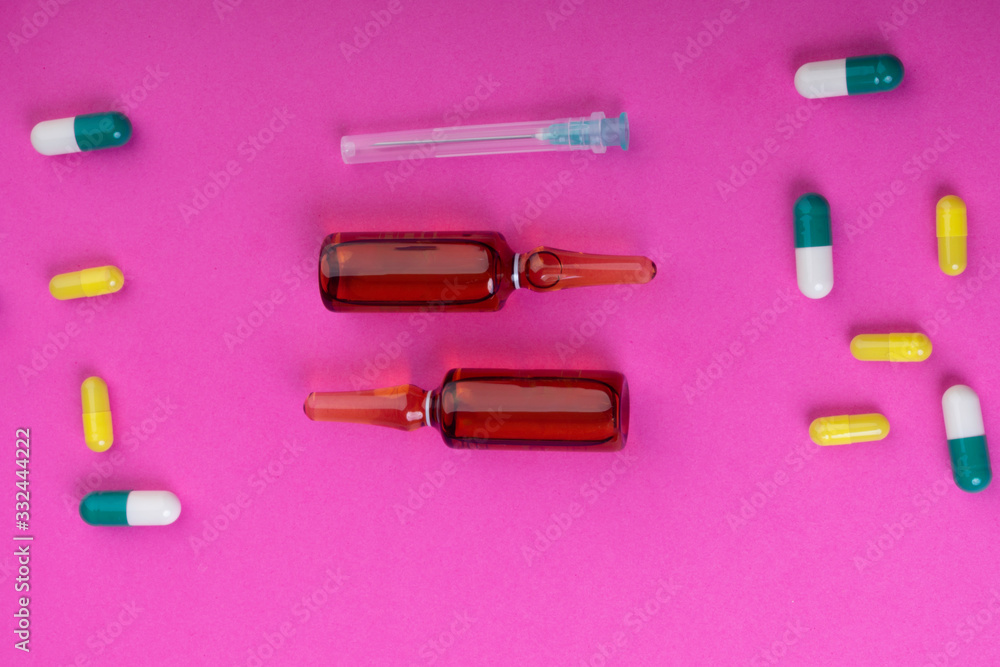 pink background with pills, needle and ampoules pink background with pills, needle and ampoules