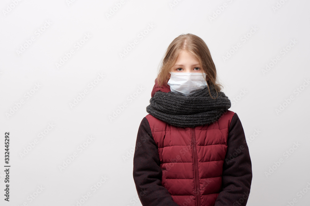 Unhappy young girl wearing face mask, grey knitted scarf and quilted maroon coat Unhappy young girl wearing face mask, grey knitted scarf and quilted maroon coat