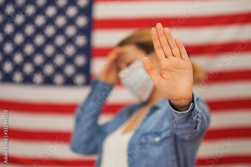 woman in the mask of the USA flag shows a stop sign. patient for outbreak COVID-19. medical in laboratory for Prevention of pandemic in Wuhan China.