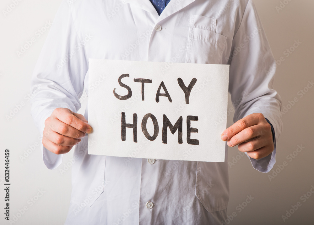 Doctor holding STAY HOME sign. Begging People with hashtag #StayHome to Fight Coronavirus. Anti nCoV Covid-19 Virus Doctor holding STAY HOME sign. Begging People with hashtag #StayHome to Fight Coronavirus. Anti nCoV Covid-19 Virus