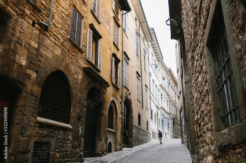 Quarantine in Italy, a lonely man walks along the deserted streets of the old city of Bergamo
