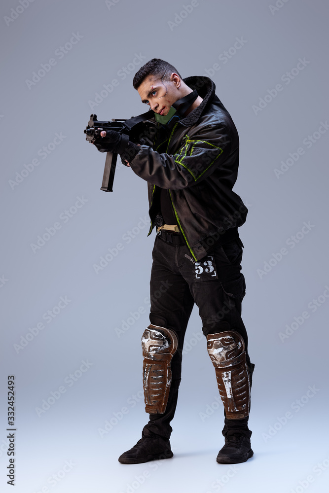 handsome bi-racial cyberpunk player aiming gun on grey handsome bi-racial cyberpunk player aiming gun on grey