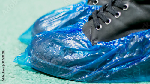 Fotografie Blue medical shoe covers are worn over shoes on the floor,  hygiene and cleanliness in medical institutions