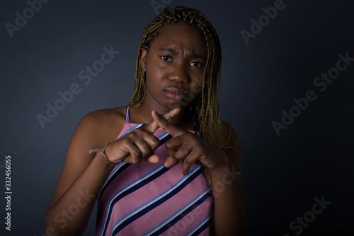 Young beautiful brunette girl wearing casual clothes over isolated background standing against gray wall. Has rejection angry expression crossing fingers doing negative sign.