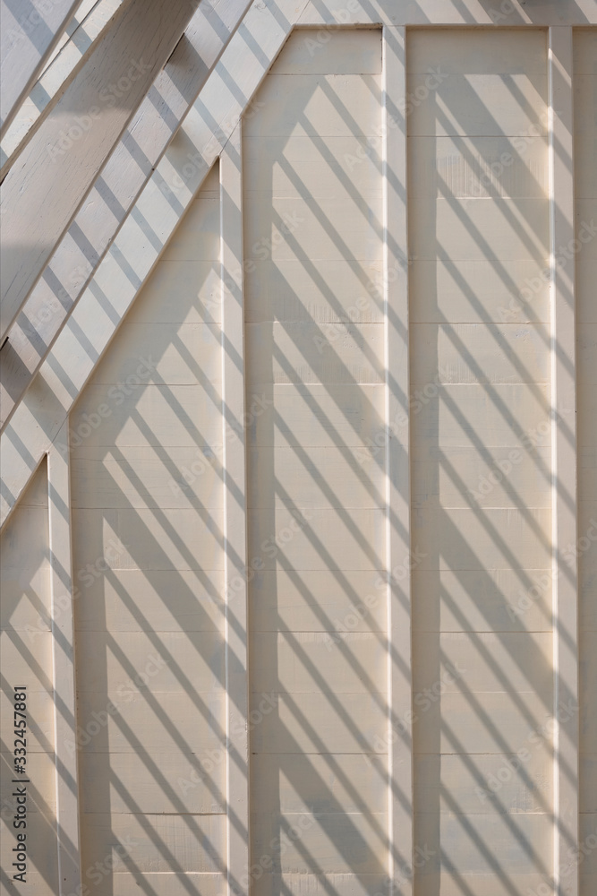 Obraz premium Sunlight and shadow on surface of white wooden roof truss structure under construction in vertical frame