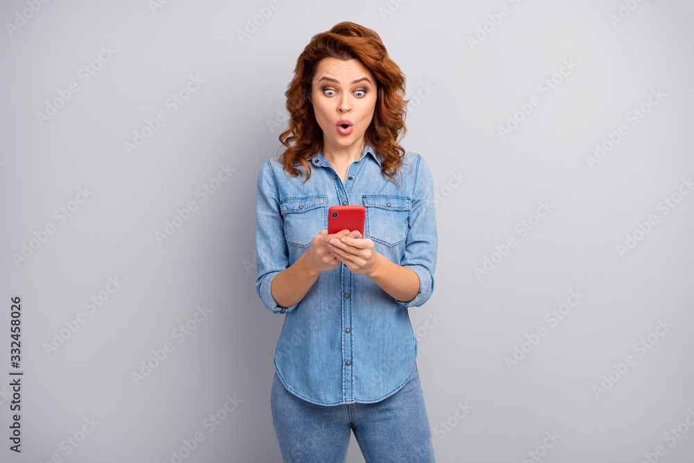 Portrait of astonished woman use smartphone read social network novelty impressed scream unbelievable unexpected wear good look outfit isolated over grey color background Portrait of astonished woman use smartphone read social network novelty impressed scream unbelievable unexpected wear good look outfit isolated over grey color background