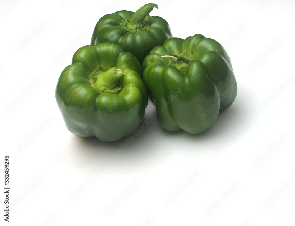 Three green peppers on a white background. Three green peppers on a white background.