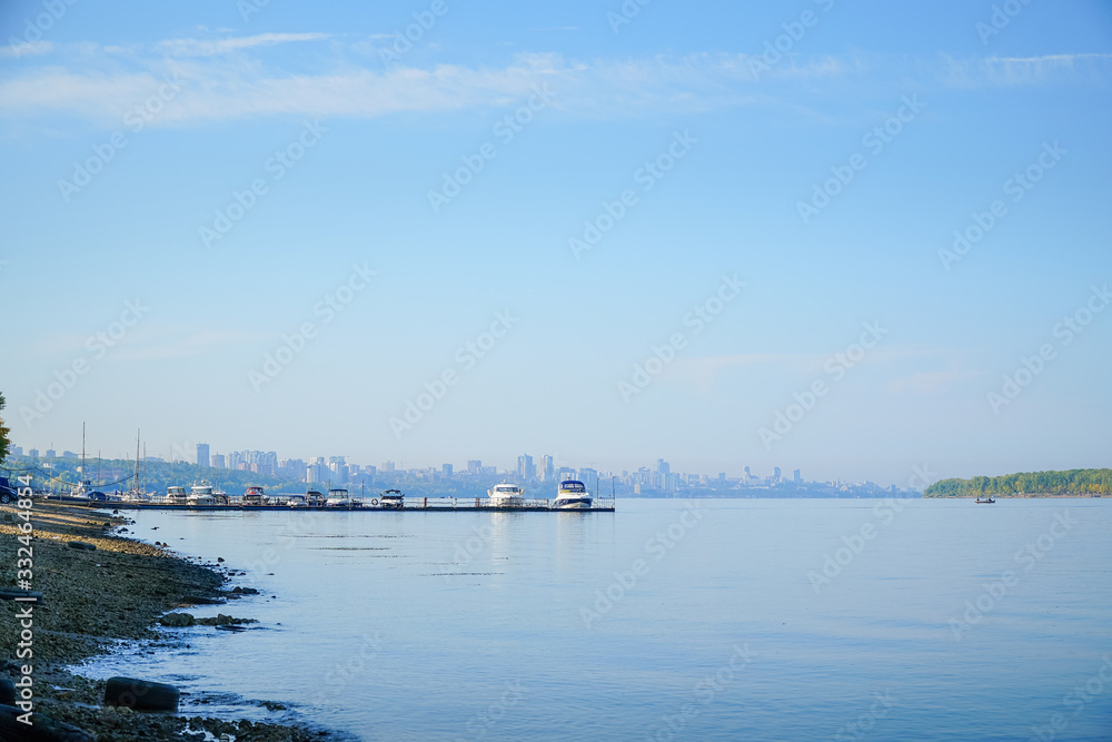 View of the big river, beyond which you can see the pier with boats and city.