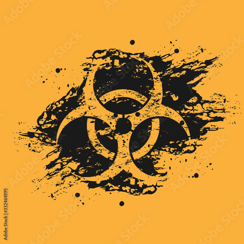 Black and orange grunge background of biological hazard. Biological hazard icon on black spots of black paint. 