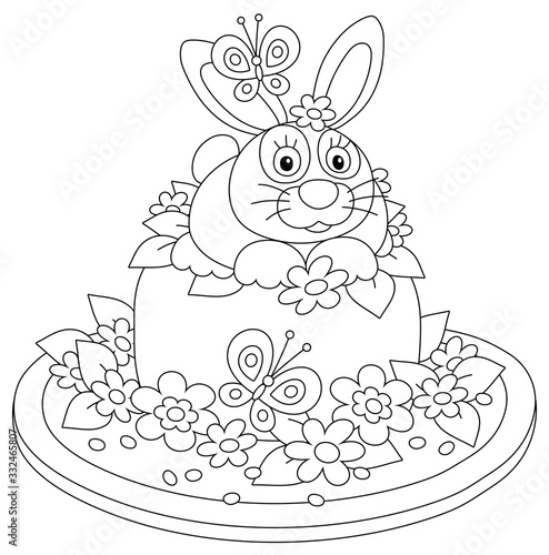 Fancy Easter toy hat made like a sweet holiday cake with a cute small bunny, garden flowers and flittering butterflies, black and white vector cartoon illustration for a coloring book