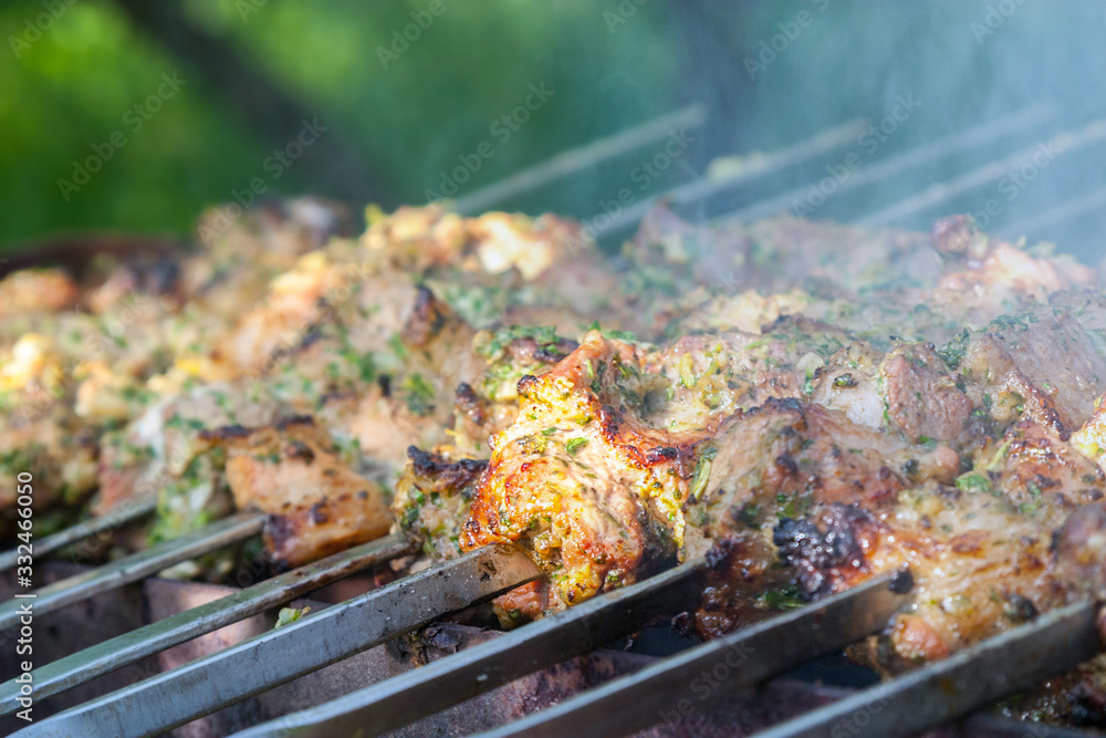 marinated pork skewers on skewers are grilled on the grill, and at the same time smoked with wooden charcoal smoke