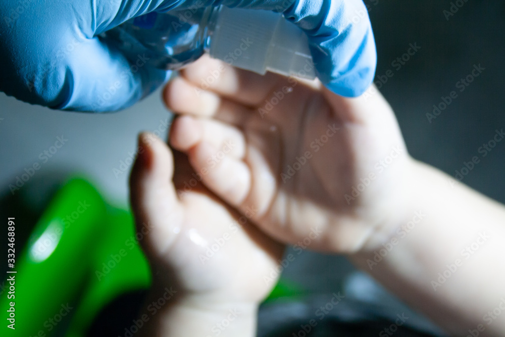 A doctor in gloves treats a child with an antiseptic A doctor in gloves treats a child with an antiseptic