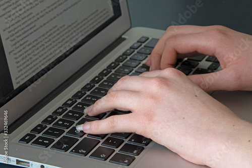 hands typing on laptop keyboard
