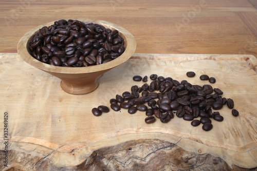 Sumatra Mandheling coffee beans in a wooden bowl and spread out before it photo