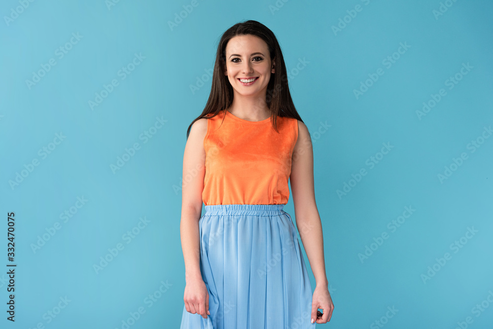 smiling and attractive woman looking at camera on blue background smiling and attractive woman looking at camera on blue background