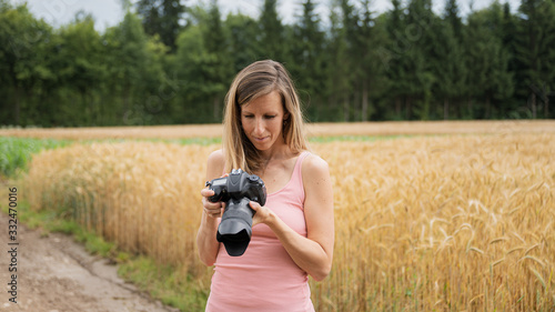 Young landscape photorapher cheking settings on her camera © Gajus
