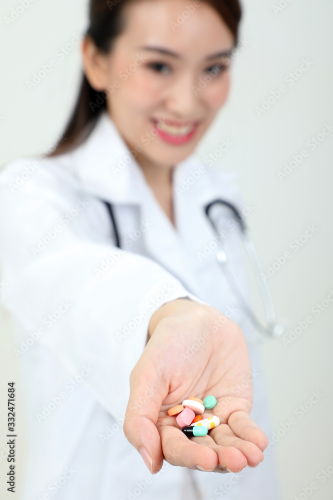 Asian doctor holding medicine capsule tablets pills on palm of hand Asian doctor holding medicine capsule tablets pills on palm of hand