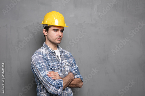 worker with yellow safety helmet in front of a concrete wall