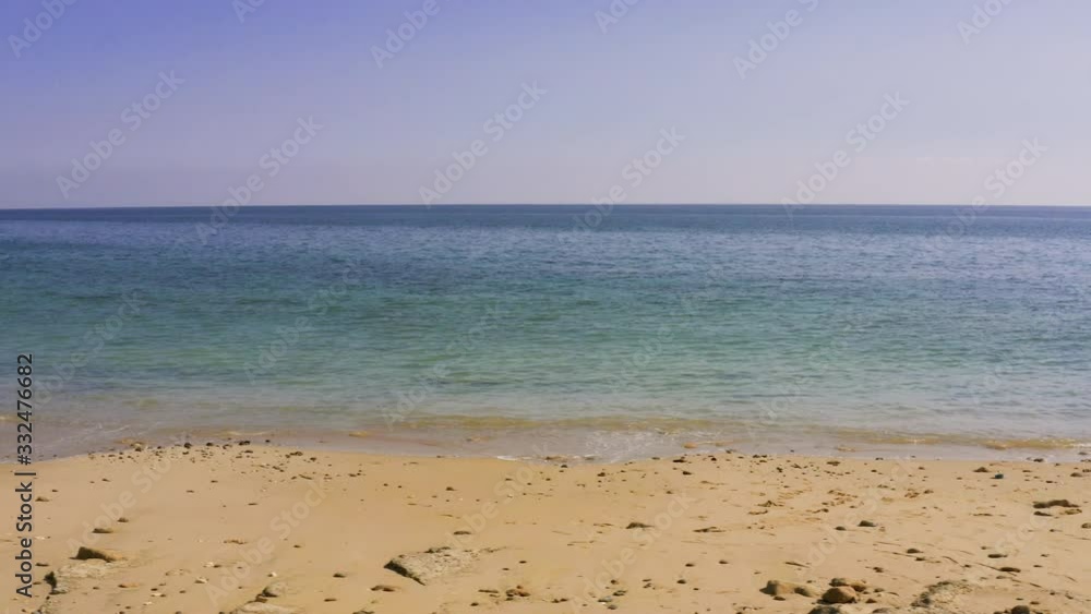 Sea or ocean, small waves, sandy beach, blue azure water, low tide at morning or evening. Camera moves along the beach, horizon view, Aerial view, drone shoot Sea or ocean, small waves, sandy beach, blue azure water, low tide at morning or evening. Camera moves along the beach, horizon view, Aerial view, drone shoot