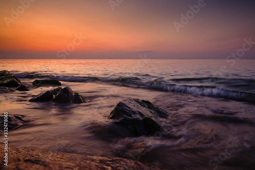 Sunrise at sea. Stones, waves and the sun. Seascape. © Dmitriy